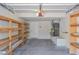A spacious garage with wooden shelving, door to interior, and utility connections at 7716 Bauble Ave, Las Vegas, NV 89128