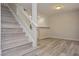 Modern staircase with wood-look steps and white railings, complementing the contemporary flooring and neutral walls at 7716 Bauble Ave, Las Vegas, NV 89128