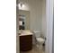 Cozy half bath featuring vanity with dark cabinets, a toilet and a mirror at 7760 Trends Ct, Las Vegas, NV 89149