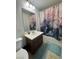 Bathroom includes a shower with colorful curtain and a vanity with a white countertop at 7760 Trends Ct, Las Vegas, NV 89149