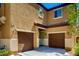 Inviting two-story home featuring a two-car garage, complemented by warm stucco and a covered entrance at 7760 Trends Ct, Las Vegas, NV 89149