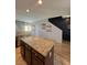 Open kitchen with island, granite counters, and stainless appliances. Staircase visible in background at 7760 Trends Ct, Las Vegas, NV 89149