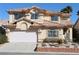Two-story home showcasing a well-manicured yard, two-car garage, and a distinctive tile roof at 8982 Emerald Waters Ct, Las Vegas, NV 89147