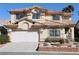 Two-story home showcasing a well-manicured yard, two-car garage, and a distinctive tile roof at 8982 Emerald Waters Ct, Las Vegas, NV 89147