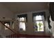 Bright living room featuring hardwood floors, large windows with elegant curtains, and a chandelier at 8982 Emerald Waters Ct, Las Vegas, NV 89147