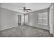 Spacious bedroom with neutral gray walls, plush carpeting, a ceiling fan, and large windows with shutter-style blinds at 9104 Pearl Cotton Ave, Las Vegas, NV 89149