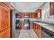 Traditional kitchen featuring dark wooden cabinets, black appliances, and updated flooring at 9104 Pearl Cotton Ave, Las Vegas, NV 89149
