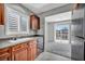 Well-lit kitchen featuring wood cabinets, gray countertops, stainless steel dishwasher, and access to a cozy eating area at 9104 Pearl Cotton Ave, Las Vegas, NV 89149