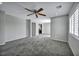 An open concept living room with grey carpeting and walls, connected to the kitchen at 9104 Pearl Cotton Ave, Las Vegas, NV 89149