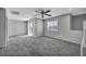 A large living room space with grey carpeting, neutral walls and a ceiling fan at 9104 Pearl Cotton Ave, Las Vegas, NV 89149