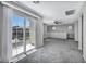 A spacious living room featuring balcony access, neutral walls, ceiling fan, and carpet at 9104 Pearl Cotton Ave, Las Vegas, NV 89149