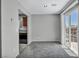 Living room with grey walls, carpet, and patio door to balcony near kitchen at 9104 Pearl Cotton Ave, Las Vegas, NV 89149