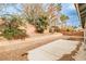 Low maintenance backyard showcasing a patio area, mature trees, and brick perimeter wall at 9514 Teton Vista Ave, Las Vegas, NV 89117