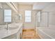 Bright bathroom featuring double vanity, walk-in shower, and soaking tub at 9514 Teton Vista Ave, Las Vegas, NV 89117