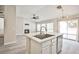 Bright kitchen island with sink and dishwasher overlooking the modern fireplace at 9514 Teton Vista Ave, Las Vegas, NV 89117