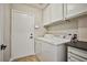 Laundry room with white cabinets, white appliances, and access to the garage at 9514 Teton Vista Ave, Las Vegas, NV 89117