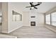 Open living room featuring gray wood floors, fireplace, and a large fan at 9514 Teton Vista Ave, Las Vegas, NV 89117