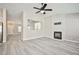 Open living room with decorative fireplace, large windows, and gray wood floors at 9514 Teton Vista Ave, Las Vegas, NV 89117