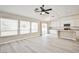 Spacious living room with gray wood floors, large windows, and access to the kitchen at 9514 Teton Vista Ave, Las Vegas, NV 89117