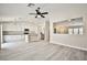 Open living space featuring gray floors, an island, and an adjacent kitchen with white cabinetry at 9514 Teton Vista Ave, Las Vegas, NV 89117