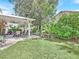 Lush backyard featuring a covered patio, green lawn, and mature landscaping, perfect for outdoor living at 9517 Mountainair Ave, Las Vegas, NV 89134