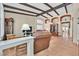 Spacious living room with exposed wood beams, terracotta tile flooring, and comfortable seating area at 9517 Mountainair Ave, Las Vegas, NV 89134