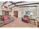 Cozy living room featuring terracotta tile flooring, exposed wood beams, and comfortable leather furniture at 9517 Mountainair Ave, Las Vegas, NV 89134