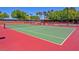 Tennis courts featuring green playing surface and red border, complete with nets, benches and dark fencing for players at 9517 Mountainair Ave, Las Vegas, NV 89134