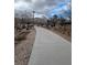 Community walking path with gravel borders, mature trees, and a light pole at 9517 Mountainair Ave, Las Vegas, NV 89134
