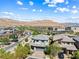 An aerial view of a home in a residential community with desert mountain views and blue skies at 7017 Pearl Hilltop Ct, Las Vegas, NV 89148