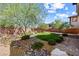 Landscaped backyard featuring lush greenery, rock features, and brick pathways at 7017 Pearl Hilltop Ct, Las Vegas, NV 89148
