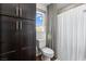 Bright bathroom featuring a toilet, dark wood cabinets, shower with curtain, and window at 7017 Pearl Hilltop Ct, Las Vegas, NV 89148