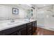 Bright bathroom with double sinks, dark wood cabinets, quartz countertops, and glass shower at 7017 Pearl Hilltop Ct, Las Vegas, NV 89148