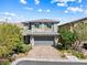 Charming two-story home featuring manicured landscaping, brick driveway, and a gray two-car garage at 7017 Pearl Hilltop Ct, Las Vegas, NV 89148