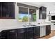 The kitchen has white subway tile, stainless appliances, and dark cabinets with a view to the backyard at 7017 Pearl Hilltop Ct, Las Vegas, NV 89148