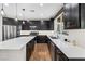 Modern kitchen features dark cabinetry, stainless steel appliances, and white quartz countertops at 7017 Pearl Hilltop Ct, Las Vegas, NV 89148