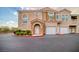 Two-story stucco townhome featuring attached garages, manicured landscaping, and private entrance at 10001 Peace Way # 2322, Las Vegas, NV 89147