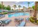 Community pool featuring lounge chairs, palm trees, and well-maintained landscaping at 10001 Peace Way # 2322, Las Vegas, NV 89147