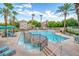 A refreshing community pool with cascading water features amidst a lush landscape of palm trees and lounge chairs at 10001 Peace Way # 2322, Las Vegas, NV 89147