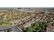 An aerial of a community with tree lined streets, green lawns, and a scenic distant cityscape at 1013 Brinkman St, Las Vegas, NV 89138
