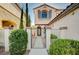 Inviting entrance with a wrought iron gate, stucco wall, decorative window, and lush landscaping at 1013 Brinkman St, Las Vegas, NV 89138