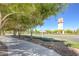 Picturesque streetscape with sidewalk and lush trees leading to a clock tower in the distance at 1013 Brinkman St, Las Vegas, NV 89138