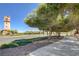 Scenic street view lined with trees and a sidewalk, leading to the prominent clock tower at 1013 Brinkman St, Las Vegas, NV 89138