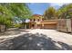 Home's large driveway and garage, with a secure gate entry and mature trees at 112 Quail Run Rd, Henderson, NV 89014
