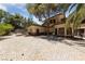 Home exterior featuring an extensive brick paver patio, side door, and mature landscaping at 112 Quail Run Rd, Henderson, NV 89014
