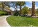 Spacious front yard with a circular driveway, lush grass, mature landscaping, and trees at 112 Quail Run Rd, Henderson, NV 89014