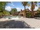 This backyard features a unique pool design and lush landscaping with mature palm trees at 112 Quail Run Rd, Henderson, NV 89014