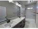 Updated bathroom featuring double sinks, granite counters, and tiled shower-tub combo at 1131 Lupin St, Pahrump, NV 89048