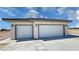 Spacious three-car garage with modern doors and exterior lighting fixtures at 1131 Lupin St, Pahrump, NV 89048