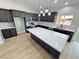 Modern kitchen boasts an island with a marble countertop, stainless steel appliances, and stylish dark wood cabinets at 1131 Lupin St, Pahrump, NV 89048